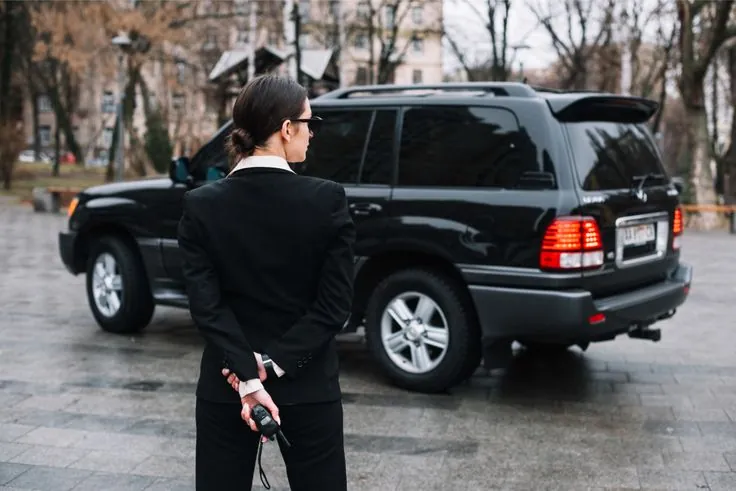 Professional executive security officer near luxury vehicle